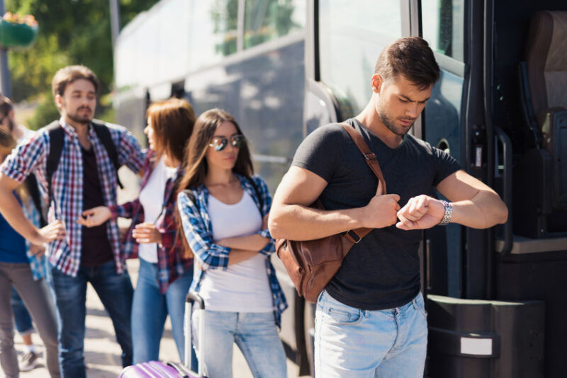 group of college students waiting to get on shuttle bus